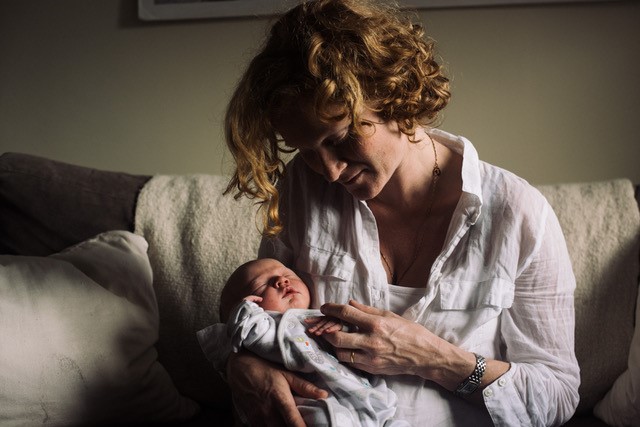 Author Jessica Hatcher-Moore with her first baby at home, days after giving birth. Jessica had a positive first experience of birth but felt poorly prepared for what came next. Image: © Philip Hatcher-Moore