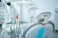 Image of an empty dental chair with dental instruments next to it