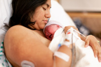 Mother Holding Brand New Baby In Hospital Delivery Room