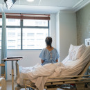 Patient on bed in a hospital looking out window
