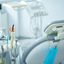 Image of an empty dental chair with dental instruments next to it