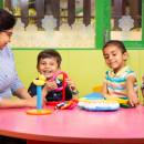 Preschool children learning toy blocks from teacher 