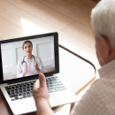 Close up older man talking with doctor online, video call