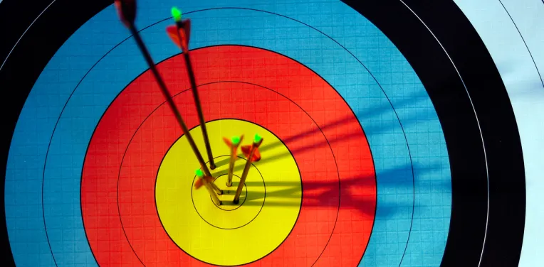 Archery target hit by four arrows