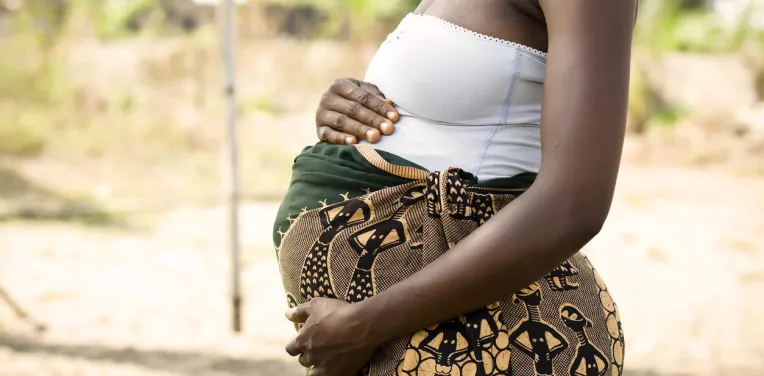 Pregnant woman in LMIC holding stomach