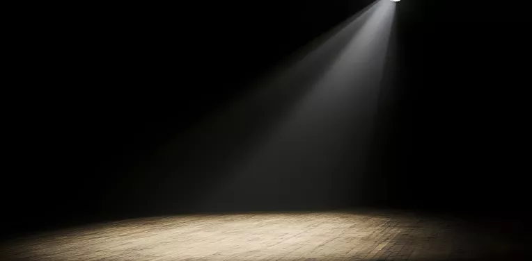 A spotlight shines on an empty stage