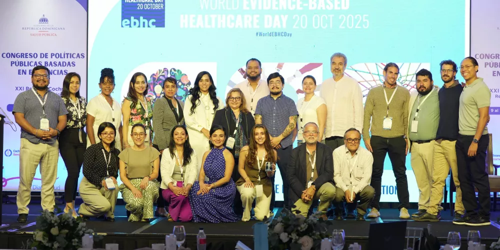 Group of people in front of a slide that says 'World Evidence-based Healthcare Day'