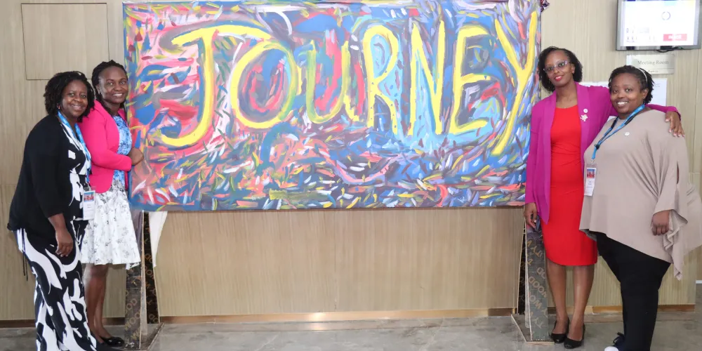 Four women standing in front of a sign that reads 'journey'