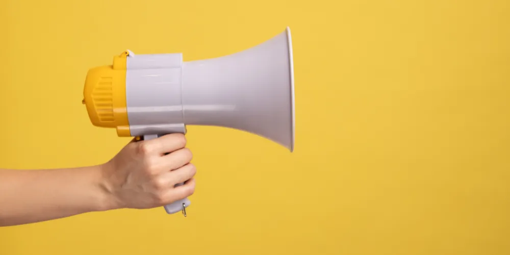 Profile side view closeup of woman hand holding megaphone
