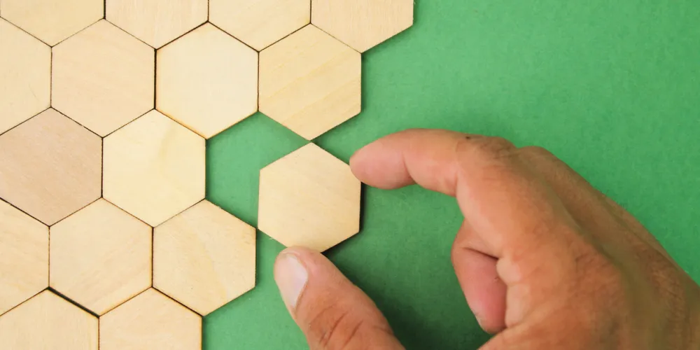 Person putting hexagonal bricks together