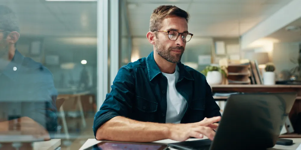 man typing on laptop