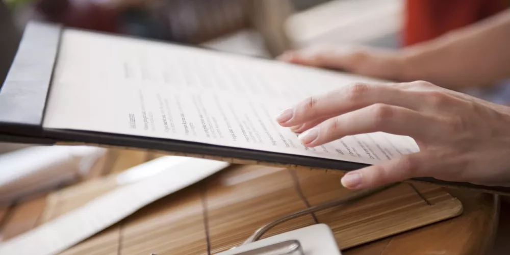Person browsing a menu at a restaurant