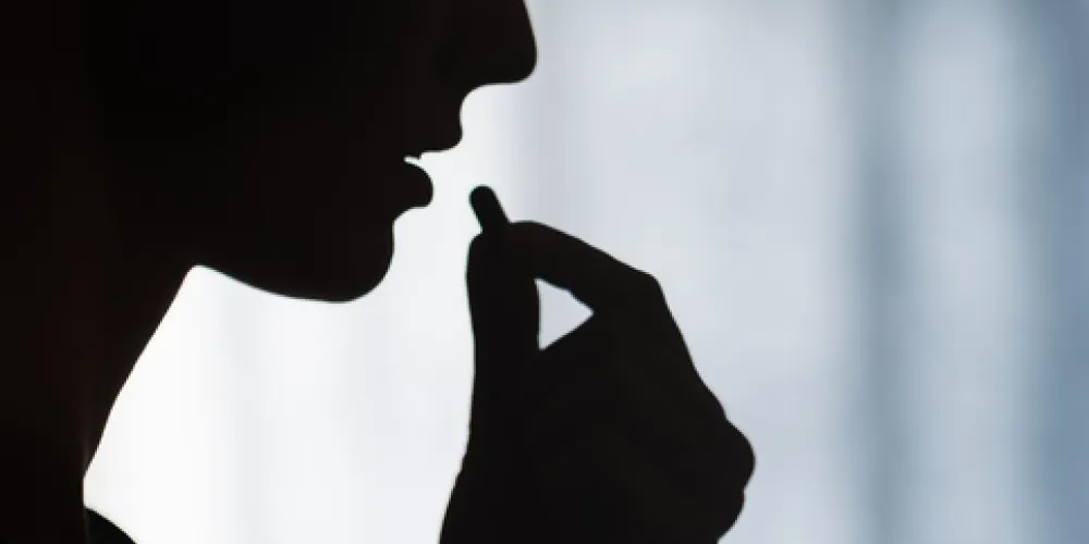 Silhouette of someone taking a tablet