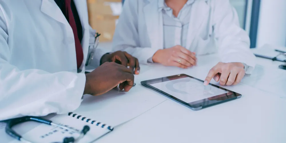 Two healthcare professionals looking at a digital tablet