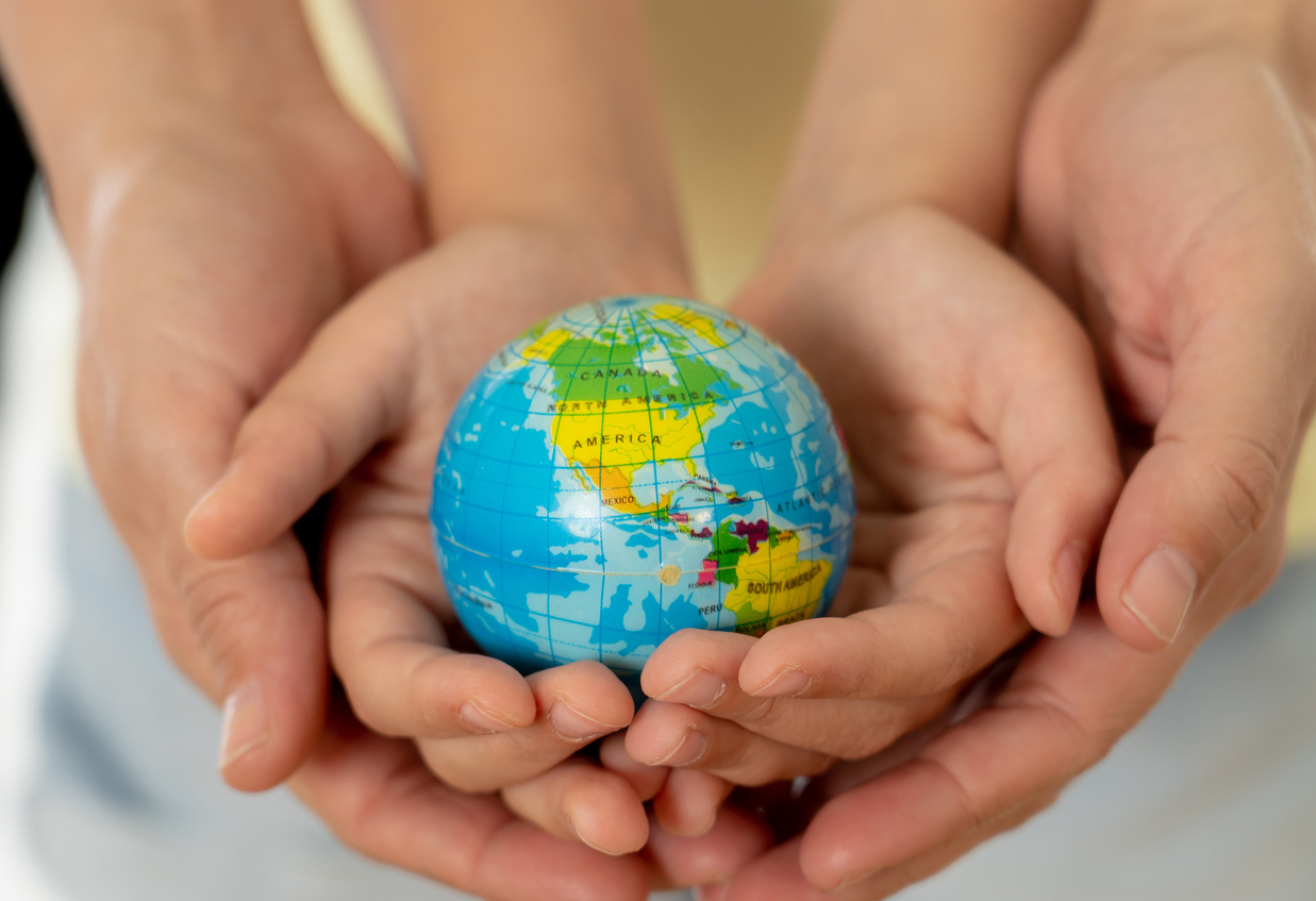 Mother and child holding hands with a globe in the centre